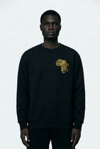 Person wearing a black sweatshirt with a gold graphic design on a white background