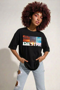 Person wearing a black t-shirt with a colorful graphic and 'DESIRE' text on a plain background