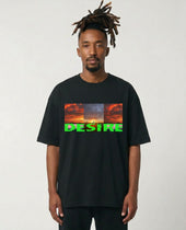 Man wearing a black t-shirt with a colorful graphic and text on a plain background