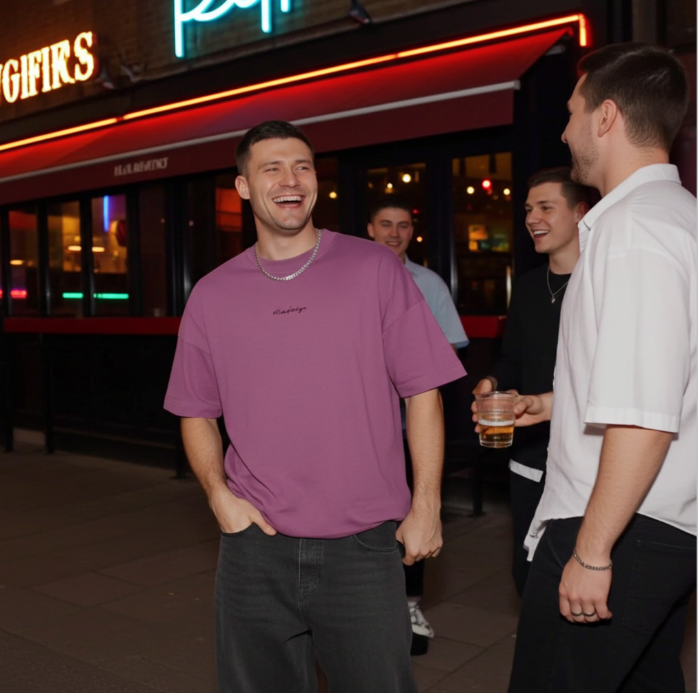 Two men laughing together outside a restaurant at night.