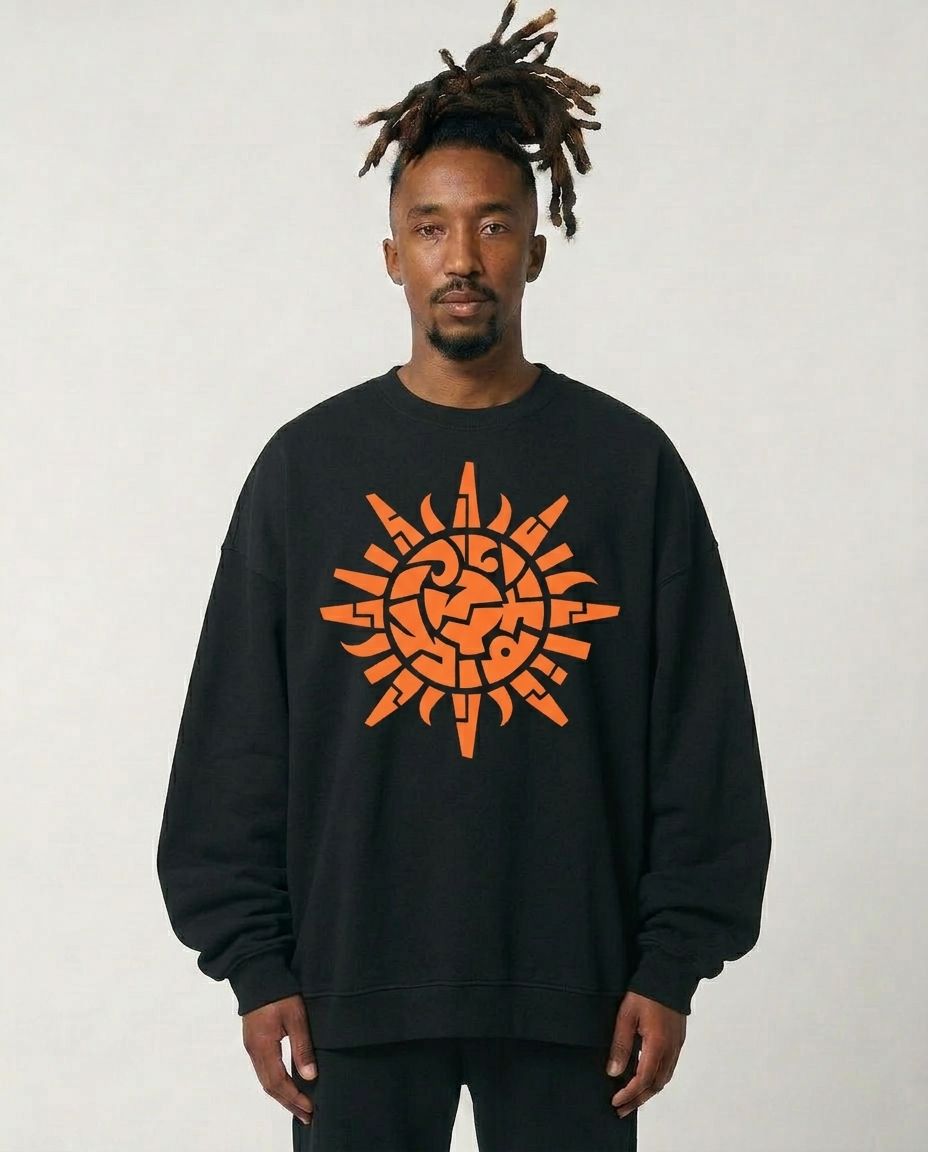 Person wearing a black sweatshirt with an orange geometric design on a plain background