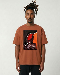 Man wearing a brown t-shirt with a graphic design on a plain background