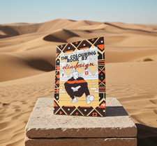 The Colouring Book by elia design on a stone platform with desert landscape in the background