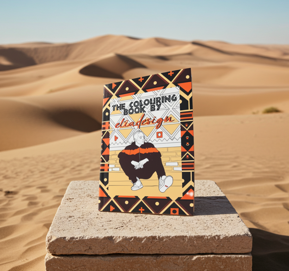 The Colouring Book by elia design on a stone platform with desert landscape in the background